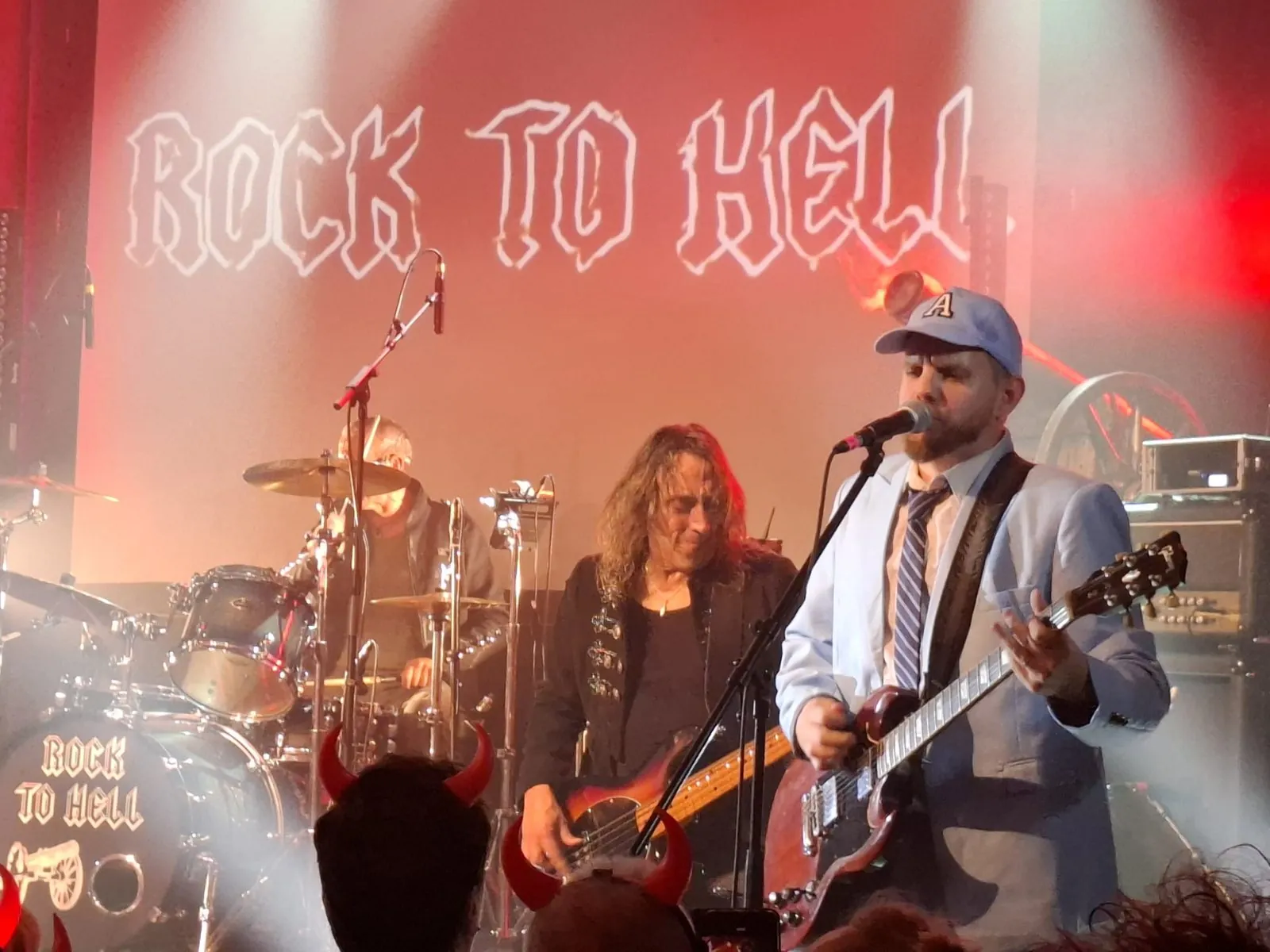 Rock To Hell au complet sur scène, logo en fond