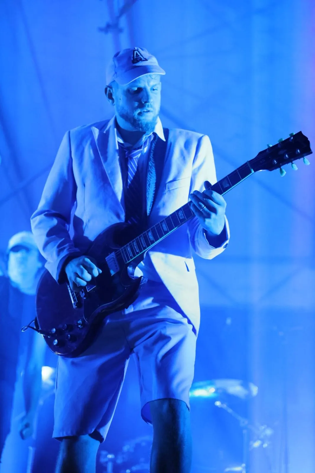 Le guitariste soliste en uniforme sous la lumière bleue